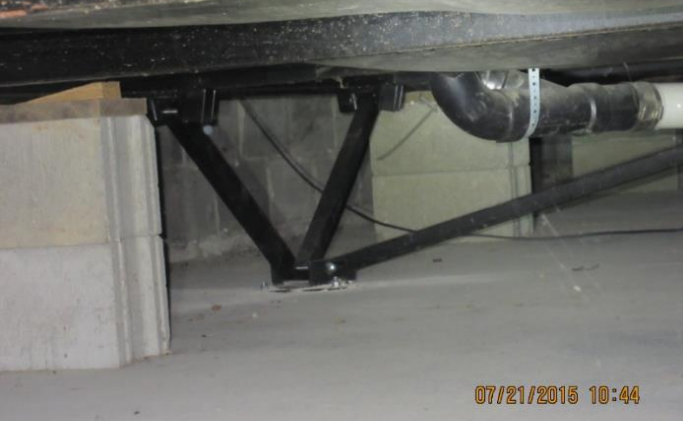 Under-home crawlspace view showing steel support piers and foundation structure